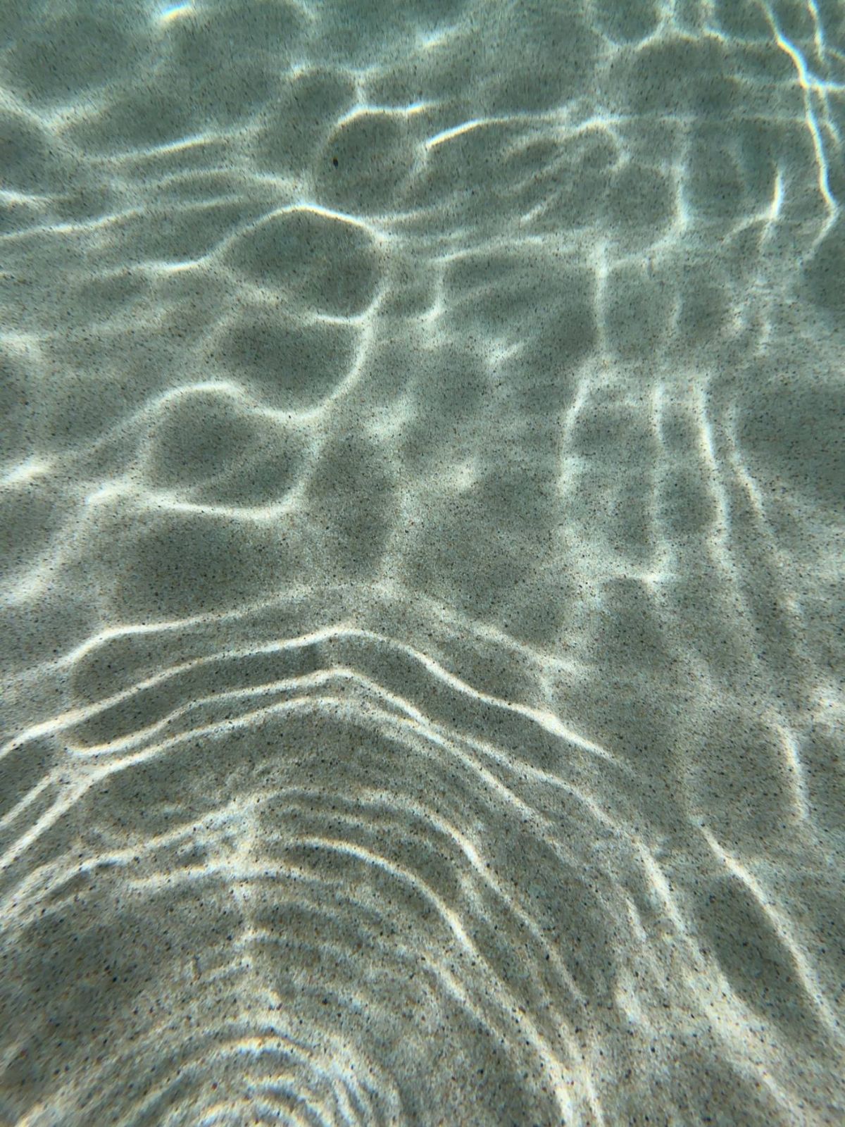 Low sun moving across clear shallow water